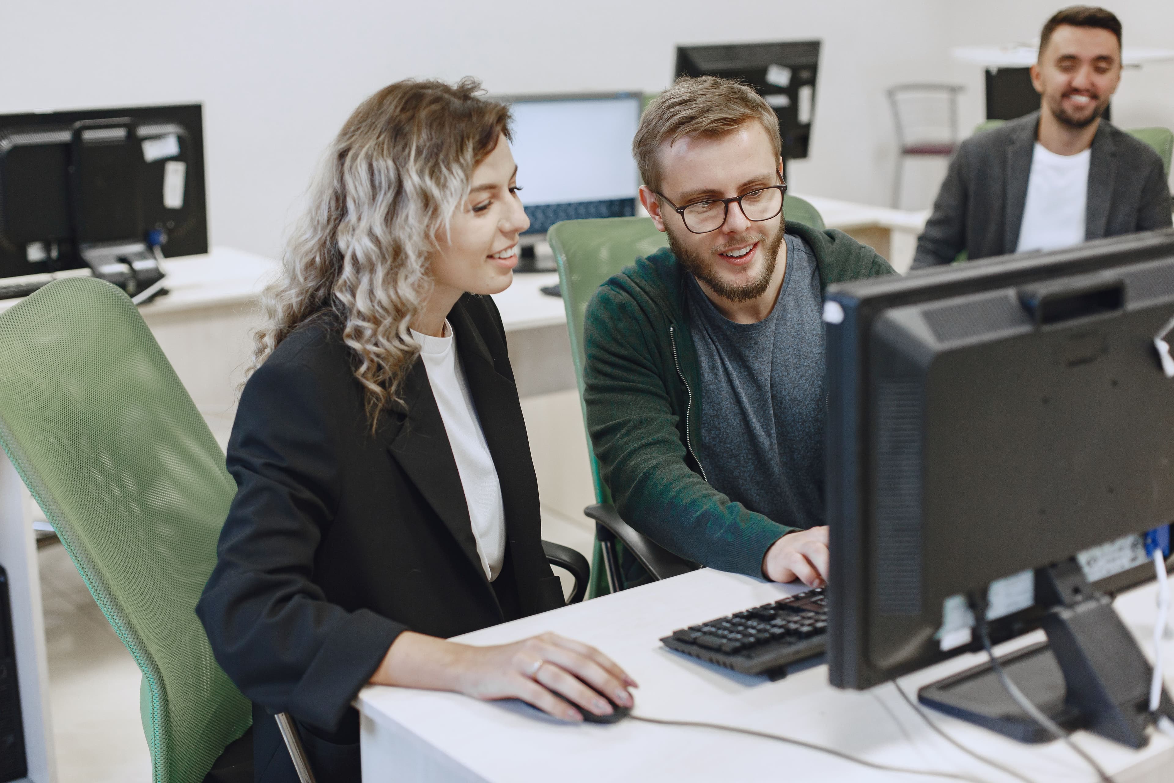 Personas trabajando juntas frente a una computadora en una oficina
